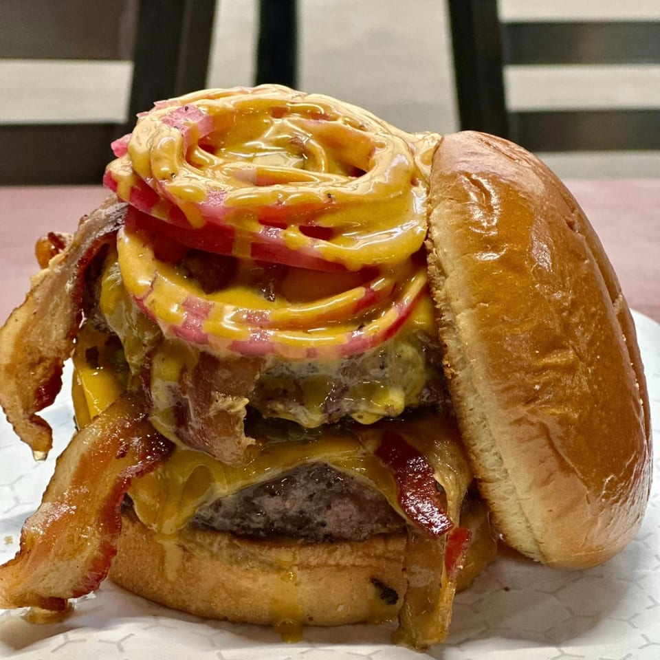 A Market Street Burgers double cheeseburger with bacon, pickled red onions, and special sauce.