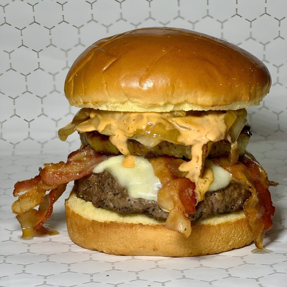 Market Street Burgers' double patty burger with bacon, melted cheese, grilled onions, and special sauce.